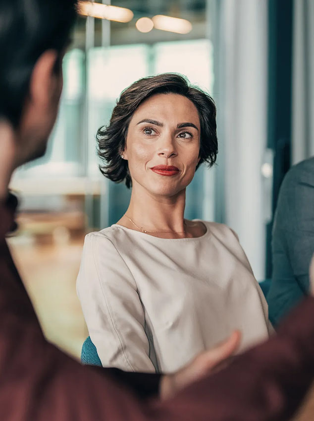 Mid adult male CEO communicating with group of his colleagues during a meeting in the office.
